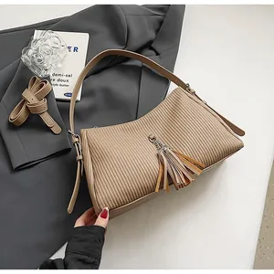 Detailed close-up of khaki pleated PU leather tote bag with tassel and adjustable strap