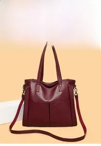 Détail du cabas rouge foncé avec texture litchi et bandoulière amovible incluse
