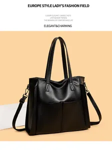Gros plan du sac cabas noir montrant le grain du cuir et les poches frontales