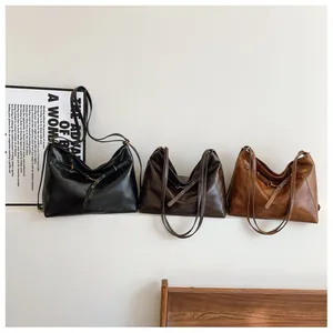 Detalle de bolsos grandes tipo tote en cuero negro, marrón oscuro y marrón amarillento