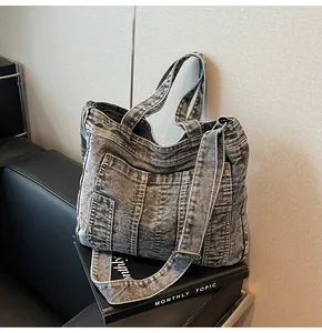 Close-up of vintage washed denim tote bag with functional pockets and adjustable strap