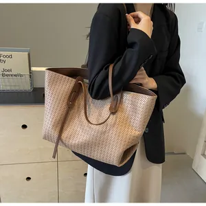 Close-up of beige woven leather tote bag with dark brown handles on model's shoulder