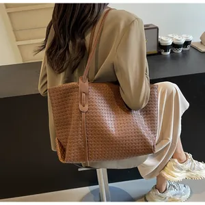 Detail of dark brown woven leather tote bag with sturdy shoulder strap for daily commuting