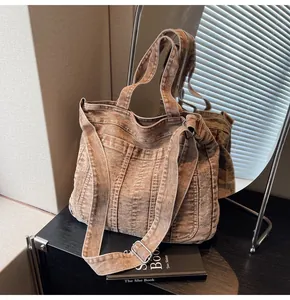 Detailed shot of vintage washed denim tote bag featuring adjustable strap and rustic texture