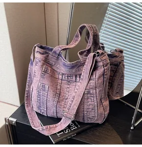 Detail of burgundy washed denim tote bag showing multiple functional pockets and stitching