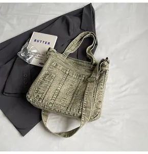 Detail of olive green washed denim tote with adjustable strap and vintage stitching
