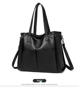 Détail du cabas en cuir PU noir avec poches avant et longue bandoulière réglable