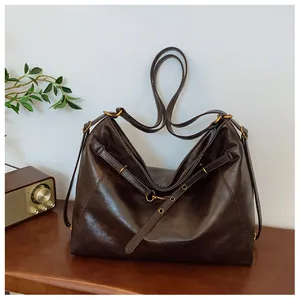 Primer plano de un gran bolso tote de cuero marrón vintage en una mesa con radio retro