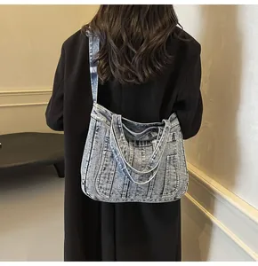 Detailed back view of a vintage blue denim tote bag styled with a long black coat