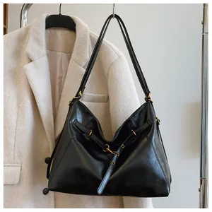 Detalle del bolso hobo de cuero negro brillante con herrajes de metal dorado antiguo