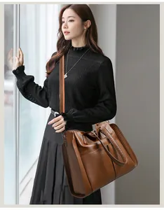 Détail du sac cabas en cuir marron avec bandoulière contrastée orange et grande contenance