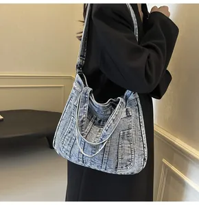 Detail of vintage washed denim tote bag with versatile long straps and short handles