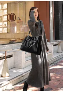 Détail d'un grand sac cabas en cuir noir texturé avec bandoulière réglable et design spacieux