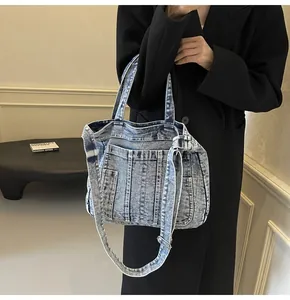 Detailed close-up of retro washed denim tote bag featuring functional front pockets and straps