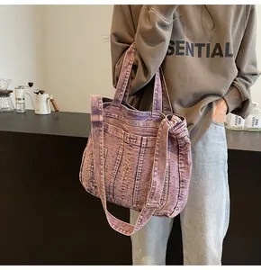 Detail of vintage purple acid wash denim tote bag with wide strap and soft texture