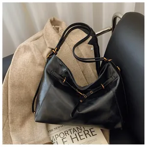 Detalle del bolso hobo de piel suave negra con herrajes dorados y correa perforada