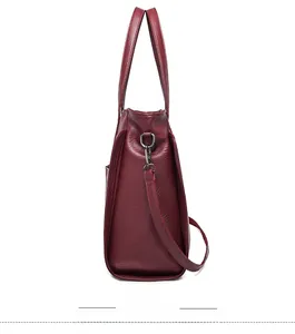 Vue latérale détaillée du sac cabas bordeaux avec texture grainée et crochets en métal