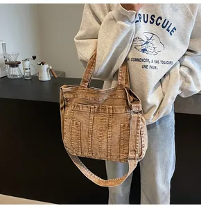 Detail of vintage washed brown denim tote bag with multiple pockets and shoulder strap