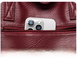 Détail d'un cabas bordeaux avec poche arrière zippée contenant un smartphone moderne