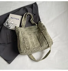 Detail of olive green washed canvas tote bag with adjustable strap on studio background