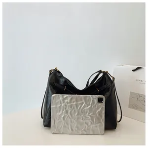 Primer plano del bolso de hombro de cuero negro con hebillas doradas y gran capacidad