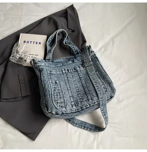 Macro shot of retro washed denim tote bag with multiple pockets on white fabric base