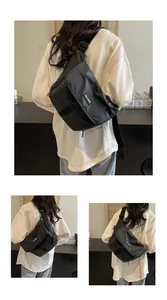 Detail of black nylon messenger bag with buckle closure and adjustable wide strap