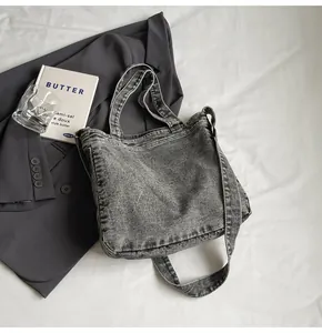 Detail of grey washed denim tote bag showing vintage texture and wide shoulder strap
