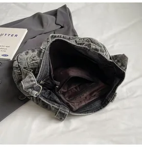 Detail shot of the large washed denim tote interior with dark brown lining and zipper pocket