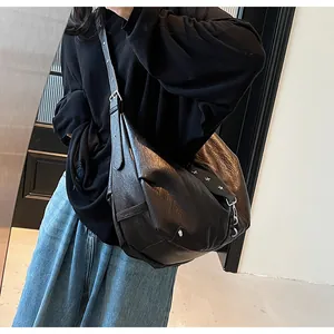 Detail of black leather tote bag with star rivets and adjustable eyelet shoulder strap