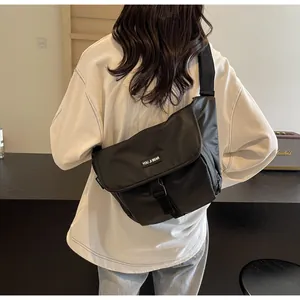 Detail view of the black waterproof nylon messenger bag with plastic buckle closure