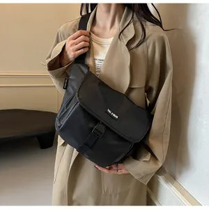 Close-up of matte black water-resistant messenger bag with adjustable strap and buckle