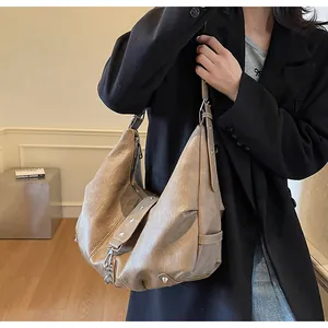 Detail of retro brown hobo bag with silver star studs and metal chain elements