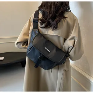 Detailed view of black waterproof messenger bag with buckle closure and brand logo