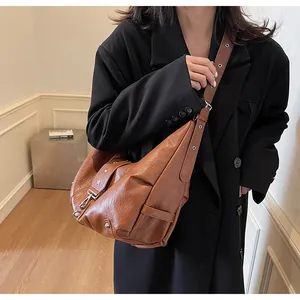 Detail of a brown PU leather tote bag featuring star studs on the shoulder strap