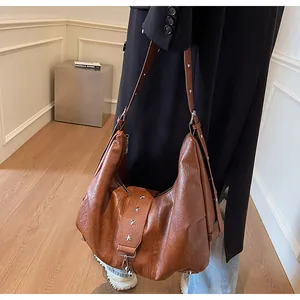 Detail of vintage brown tote bag with star rivets and adjustable shoulder strap