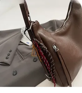 Detail of coffee brown moon bag with lychee texture and silver metal zipper accent