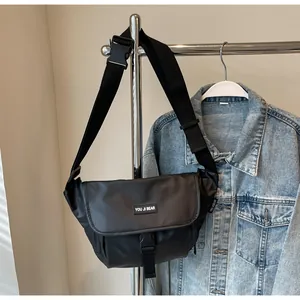 Close-up of waterproof black crossbody bag with flap buckle and adjustable shoulder strap