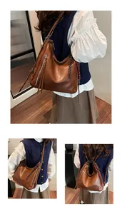 Detail showing the brown PU leather hobo bag with a decorative woven rope charm