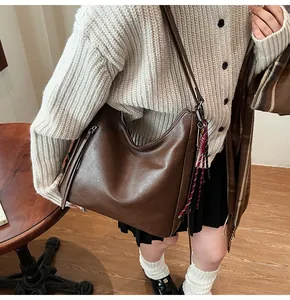 Detail of a vintage dark brown leather hobo bag with wide strap and side zipper decoration