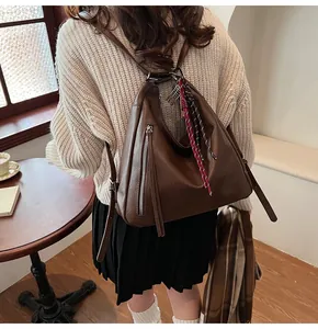 Detail of vintage brown PU leather tote bag with tassel zipper and decorative rope
