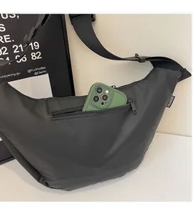 Detail of black crossbody bag with front zipper pocket showing large capacity for smartphone