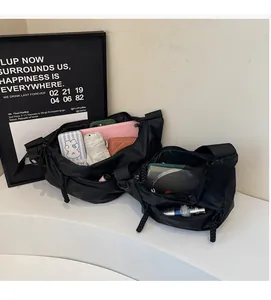 Detail showing the large interior capacity of this black nylon crossbody dumpling bag