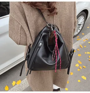 Close-up of black PU leather tote bag featuring a red braided rope and key charm