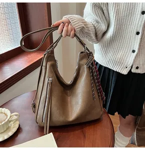 Detailed view of the brown PU leather tote bag featuring a metal zipper and soft texture