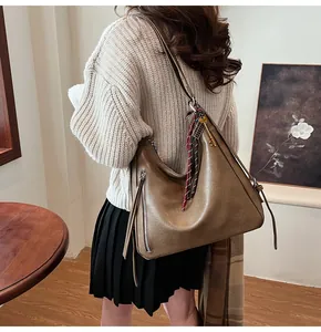 Detail of dark brown faux leather tote with vintage key pendant and woven strap
