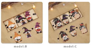 Detail of Halloween wooden gnomes with pumpkin and witch hat ornaments on burlap background