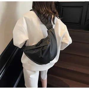 Rear view of model wearing a minimalist black waterproof crossbody bag on a nylon strap