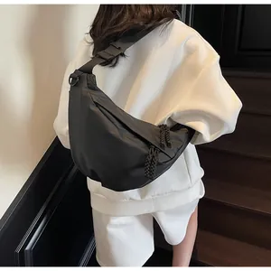 Detail of adjustable strap and water-resistant nylon texture on black crescent crossbody bag