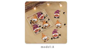 Detail of wooden Halloween gnome pendants with pumpkin lamps in a wooden grid box display